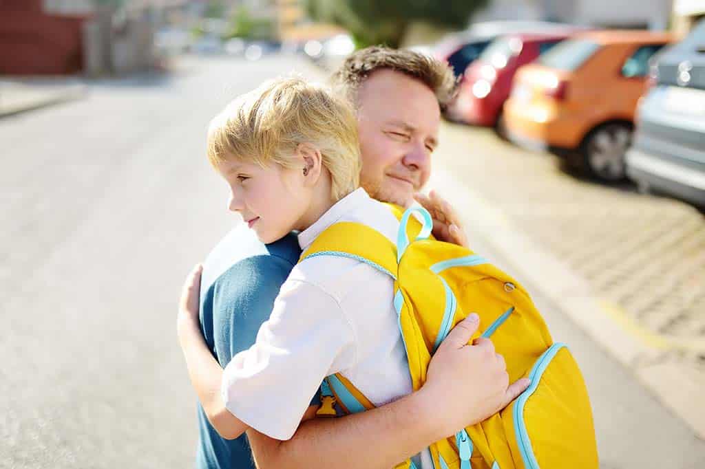 Father hugging daughter during morning drop-off