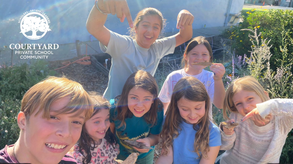 kids smiling at the camera, outside in the sun - ready for summer camp!