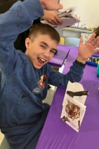 Courtyard School Sacramento - smaller class sizes, boy celebrating his artwork