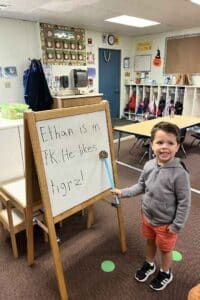 TK vs. Kindergarten, Courtyard School - TK child smiling in a classroom