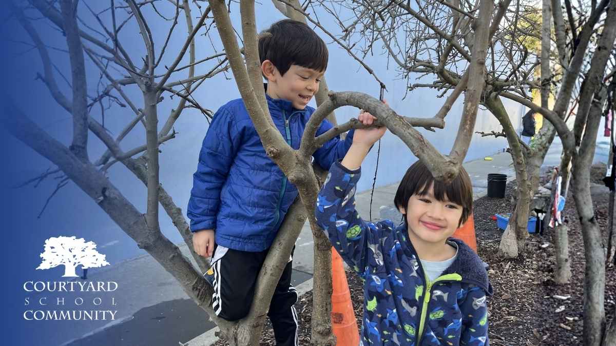 tk vs kindergarten, Courtyard School - Two kindergarteners smiling and playing around some trees