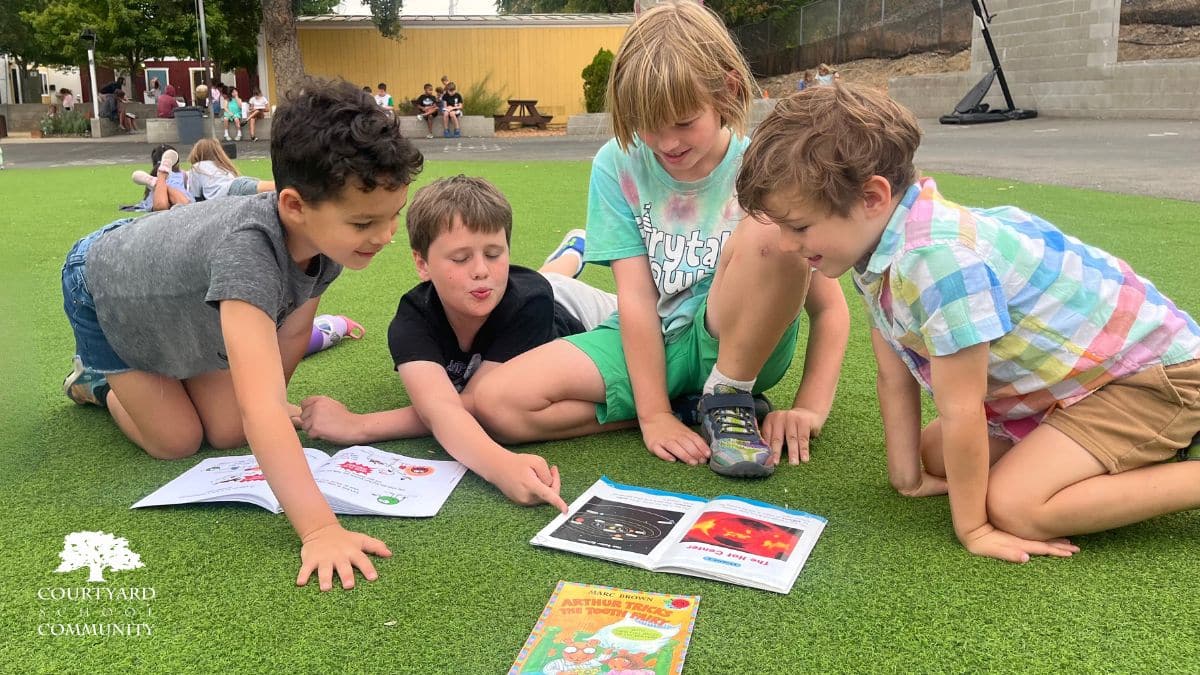 A Day at Courtyard - four kids read outside at Courtyard School